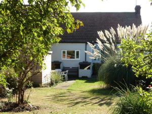 a garden with a house with a bench and plants at Beautiful 'Rose-Dene' with ample parking in Sheerness