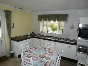 a kitchen with a table and chairs in it at Beautiful 'Rose-Dene' with ample parking in Sheerness