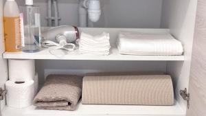 a white shelf with towels and towels in a bathroom at Studio récent avec terrasse Clim Airbus Aéroport in Colomiers +29 photos