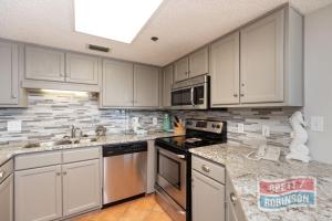 a kitchen with white cabinets and stainless steel appliances at Phoenix East II 2072 in Orange Beach