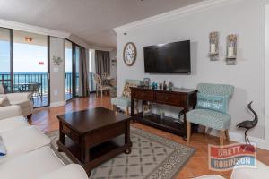 a living room with a couch and a table and a tv at Phoenix East II 2072 in Orange Beach