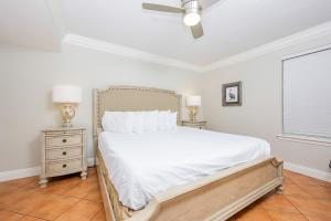 a bedroom with a bed with white sheets and a ceiling fan at Phoenix East II 2072 in Orange Beach +31 photos
