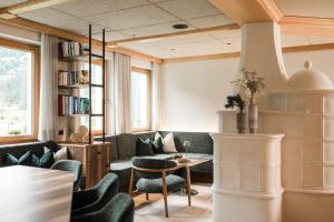 a living room with chairs and a table and bookshelves at Residence Sovara in Santa Cristina in Val Gardena