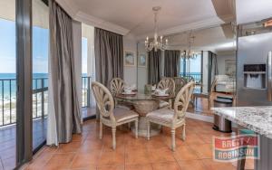 a dining room with a table and chairs and a balcony at Phoenix East II 2072 in Orange Beach