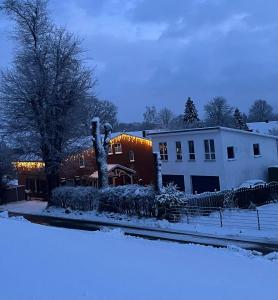 una casa con la neve per terra davanti di Cottage an der Elbe Tespe Hamburg a Tespe