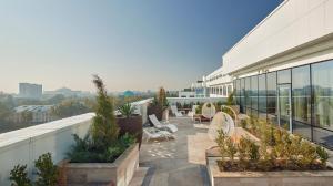 een balkon met stoelen en planten in een gebouw bij Hyatt Regency Tashkent in Tasjkent