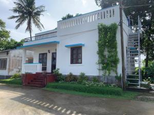 a white house with a tree at Junput Guest House in Bichania
