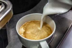una tazza di caffè con latte versato dentro di Spread Eagle Inn a Stourton