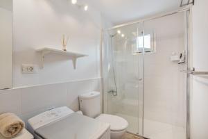 a white bathroom with a shower and a toilet at Villa Star in Agaete +16 photos