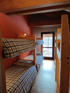 a room with three bunk beds in a cabin at Rifugio Alevé in Castello +8 photos
