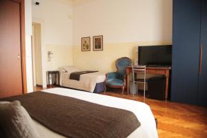 a bedroom with a bed and a desk and a television at Albergo Garisenda con terrazza panoramica sulle Due Torri in Bologna +170 photos