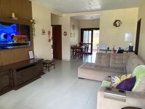 a living room with a couch and a tv at Refúgio Familiar Kingdom in Tramandaí