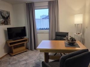 a living room with a television and a table with a table at Haus Barbara Ott in St. Blasien
