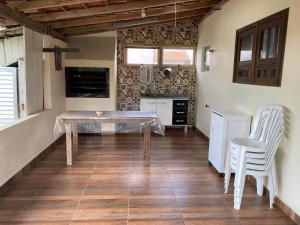 a kitchen with a table and chairs in a room at Refúgio Familiar Kingdom in Tramandaí