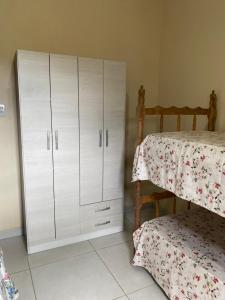 a bedroom with a white cabinet next to a bed at Refúgio Familiar Kingdom in Tramandaí