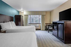 a hotel room with two beds and a flat screen tv at Best Western Long Beach Inn in Long Beach