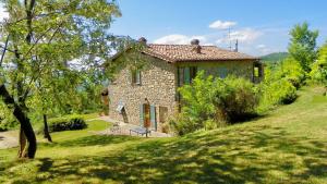 a small stone house on a grassy hill at Casa al Vento in Talla