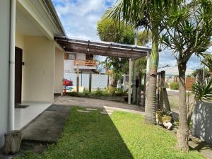 a house with a garage and a palm tree at Refúgio Familiar Kingdom in Tramandaí