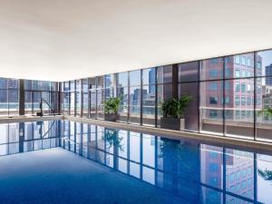 een binnenzwembad in een gebouw met ramen bij Mantra Southbank in Melbourne