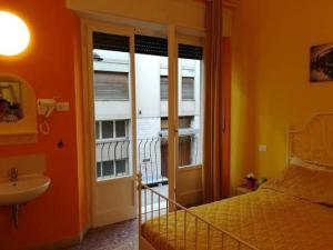 a bedroom with a bed and a sink and a window at pisa train station hostel in Pisa