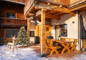 un ponte di legno con un tavolo e un albero di Natale di GondelApart Ski in Ski out a Jochberg