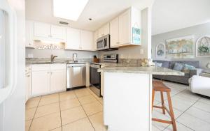 a kitchen and living room with white cabinets and a counter at Phoenix East II 2092 in Orange Beach
