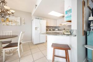 a kitchen with a white refrigerator and a table at Phoenix East II 2092 in Orange Beach