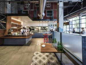 een restaurant met een tafel en mensen in de keuken bij Art Series - The Larwill Studio in Melbourne