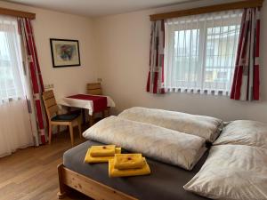 a bedroom with two beds and a table and windows at Ferienwohnung Mayrhofer in Leogang