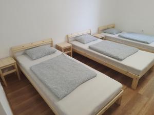 a group of three beds in a room at Napfény Tanya in Tázlár