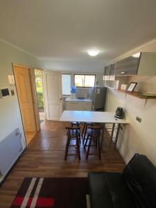 a kitchen with a table and chairs in a room at Rancho Carmelitas Cabañas Familiares en Pullally, comuna Papudo in Quinquimo