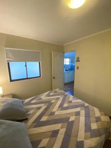 ein Schlafzimmer mit einem Bett und einem Fenster in der Unterkunft Rancho Carmelitas Cabañas Familiares en Pullally, comuna Papudo in Quinquimo