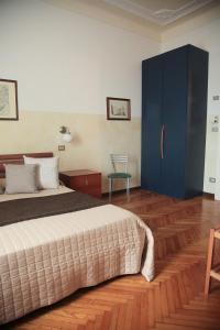 a bedroom with a bed and a blue cabinet at Albergo Garisenda con terrazza panoramica sulle Due Torri in Bologna