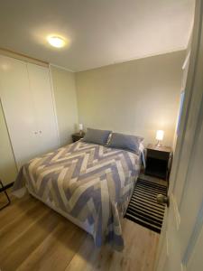 a bedroom with a bed with two night stands and two lamps at Rancho Carmelitas Cabañas Familiares en Pullally, comuna Papudo in Quinquimo