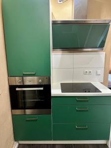 una cucina verde e bianca con piano cottura di Stilvolles Landhausstil Apartment - Zentral a Brema