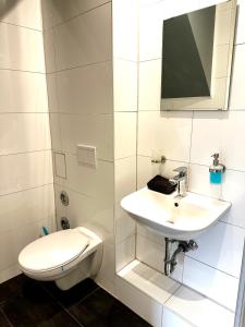 un bagno bianco con un water e un lavandino di Stilvolles Landhausstil Apartment - Zentral a Brema 1 altra foto