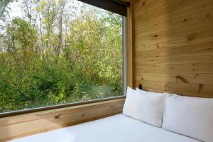 a bed in a room with a large window at Postcard Cabins Starved Rock, Outdoor Collection by Marriott Bonvoy in Ottawa