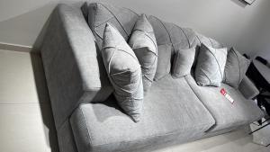 a couch with six pillows on it in a room at Sweet li junior in Ashkelon