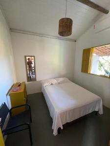 a bedroom with a bed and a chair in it at CARAÍVA House in Caraíva