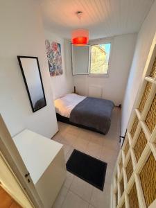 een kleine slaapkamer met een bed en een raam bij Chez Theo in Marseille