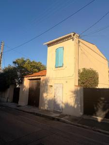 een wit huis met een blauw raam aan een straat bij Chez Theo in Marseille