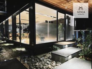 een gebouw met grote ramen en rotsen ervoor bij SENJA Dewata in Mitoyo