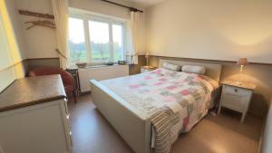 a bedroom with a bed and a window at Le Pré en Bulles in Chiny