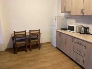a kitchen with a table and two chairs and a microwave at Студія в центрі міста , 7 поверх без ліфту in Ivano-Frankivsk +13 photos