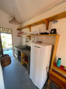 a kitchen with a white refrigerator in a room at CARAÍVA House in Caraíva