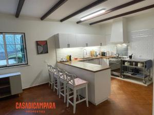 a kitchen with a counter and some chairs in it at Casa di Campara Almada Villa in FAO