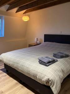 een slaapkamer met een bed met twee handdoeken erop bij vakantiewoning Het Boomkwekerijhuis in Zonnebeke