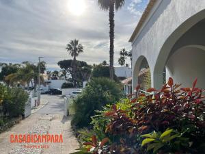 a street in front of a house with palm trees at Casa di Campara Almada Villa in FAO