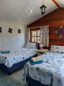 two beds in a room with wooden walls at Gegund Guest Accomodation in Parys