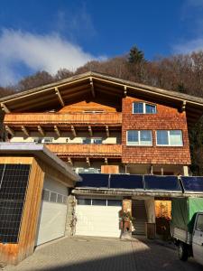 a house with two garage doors and a van parked in front at Ferienwohnung Mayrhofer in Leogang